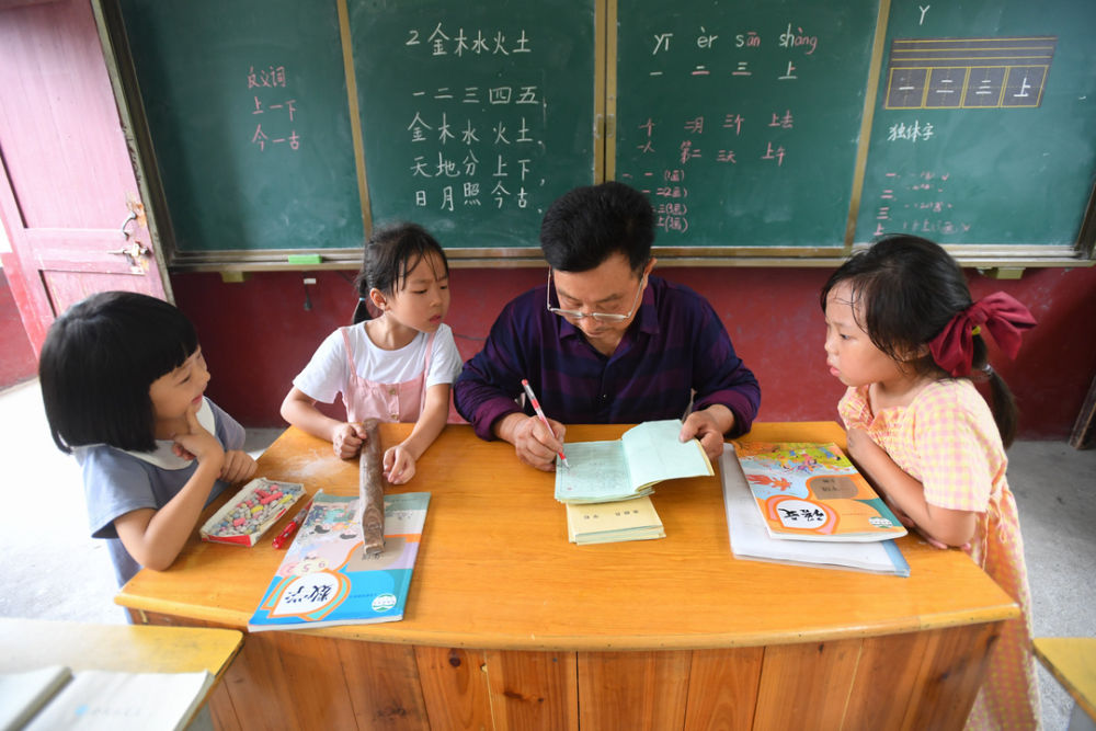 在湖南省株洲市茶陵县的虎踞镇茶干小学,乡村教师董朱文(右二)在批改语文作业(2020年9月8日摄)。新华社记者 陈泽国 摄