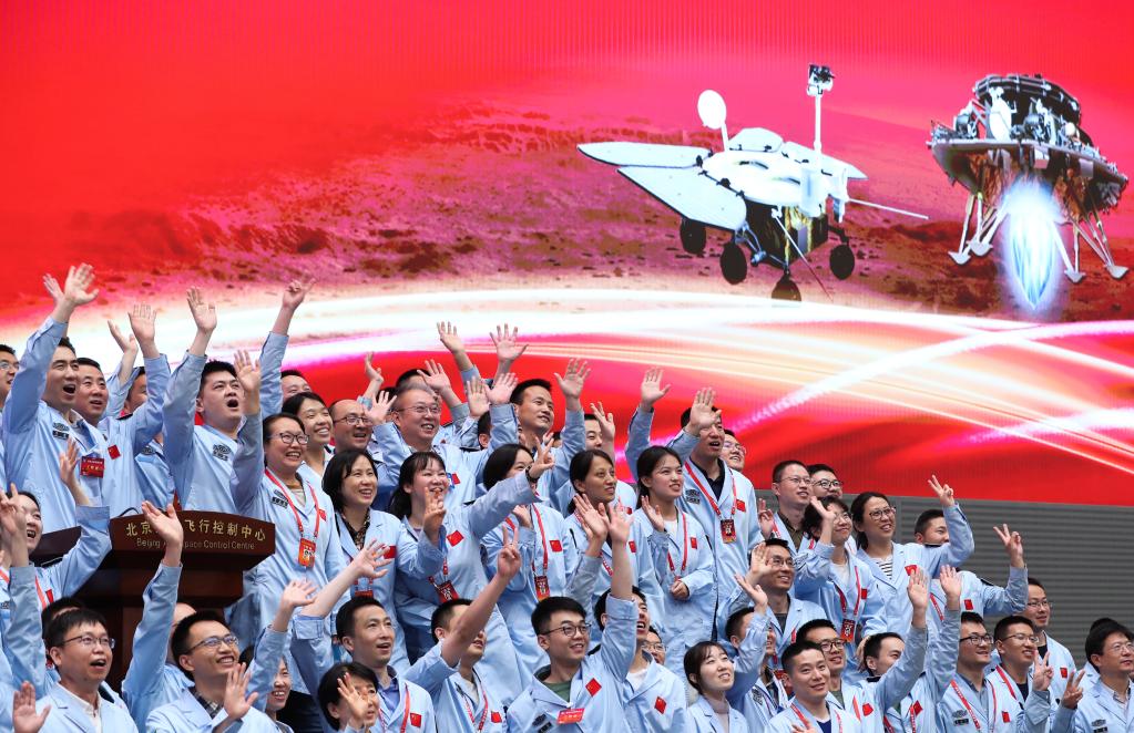 5月15日,航天科研人员在北京航天飞行控制中心指挥大厅庆祝我国首次火星探测任务着陆火星成功。 新华社记者 金立旺 摄